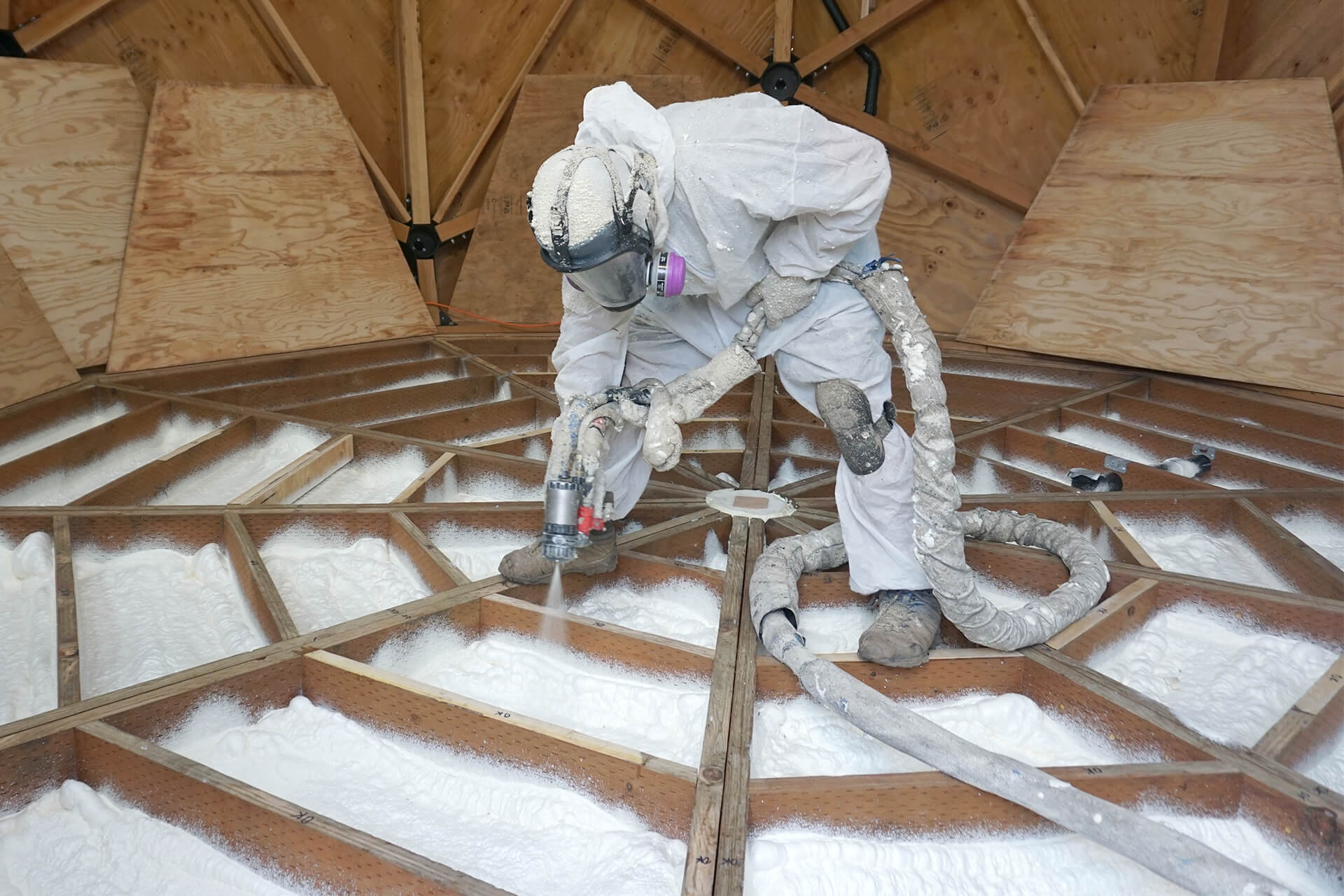 Spray polyurethane foam being installed between the floor joists.
