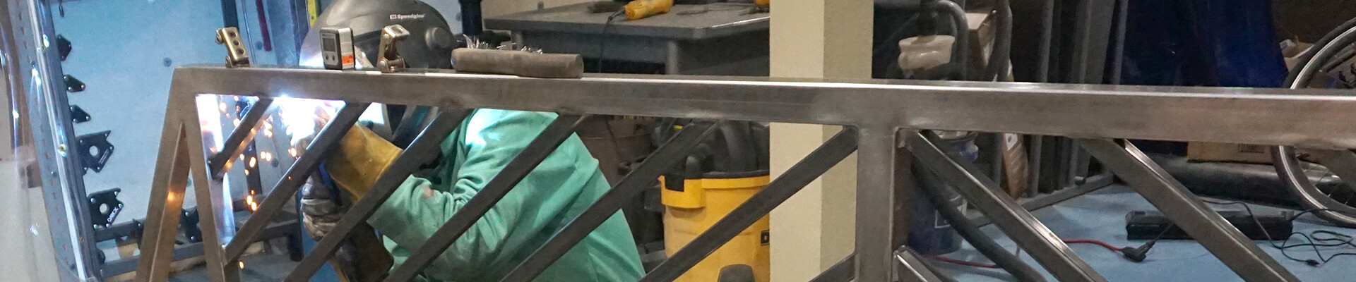 A close-up view of welding the Mini Dome custom steel railing.