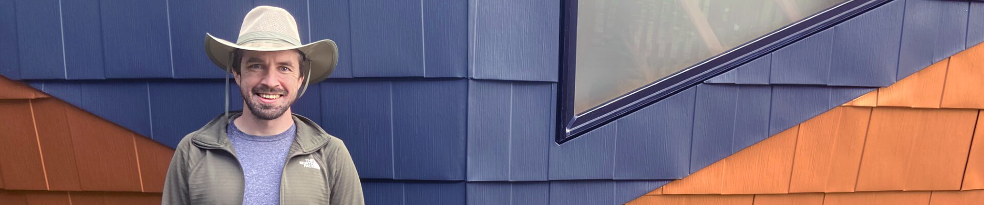 A close-up view of Joshua Tulberg, the owner and builder, standing in front of the mini dome.